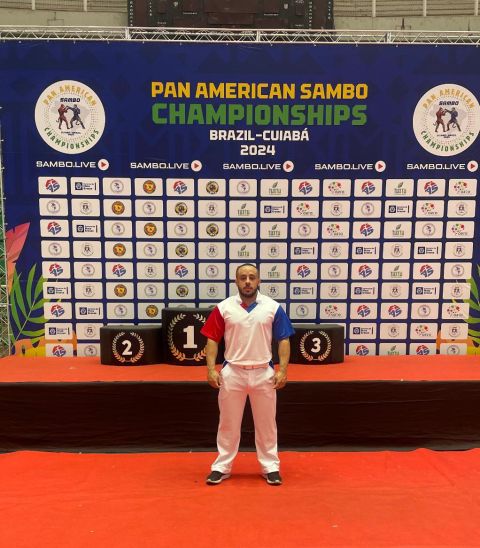 Árbitro Caio Cordeiro diante do pódio do Pan American Sambo Championships Brazil-Cuiabá 2024