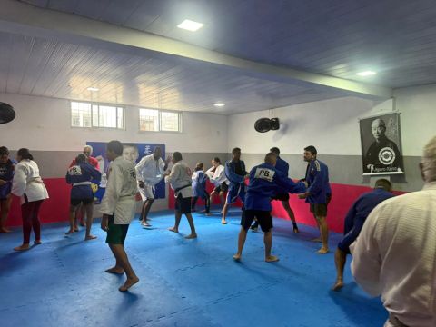 Alunos treinam técnicas de SAMBO em duplas no tatame azul durante o curso em Pernambuco